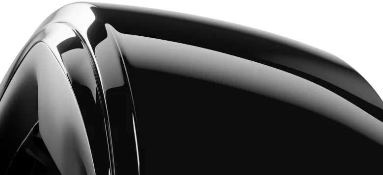 Close-up of a shiny, black ring surface with smooth, curved edges, reflecting light. The surface appears polished and glossy.